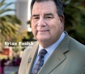 Portrait of Brian Paish, city council candidate, in a suit outdoors.